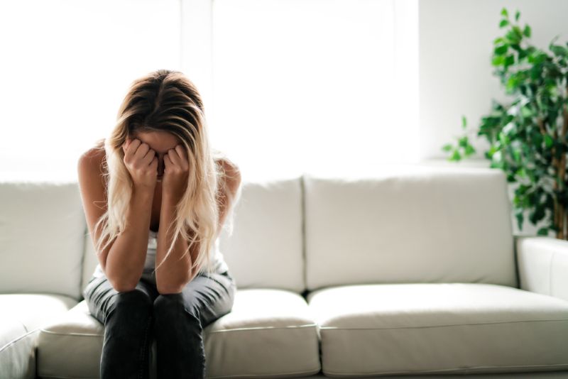 sad and lonely woman alone in living room