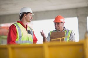 two construction workers talking to each other on the job