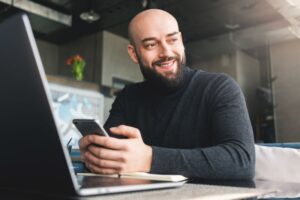 businessman sitting and smiling while working on laptop