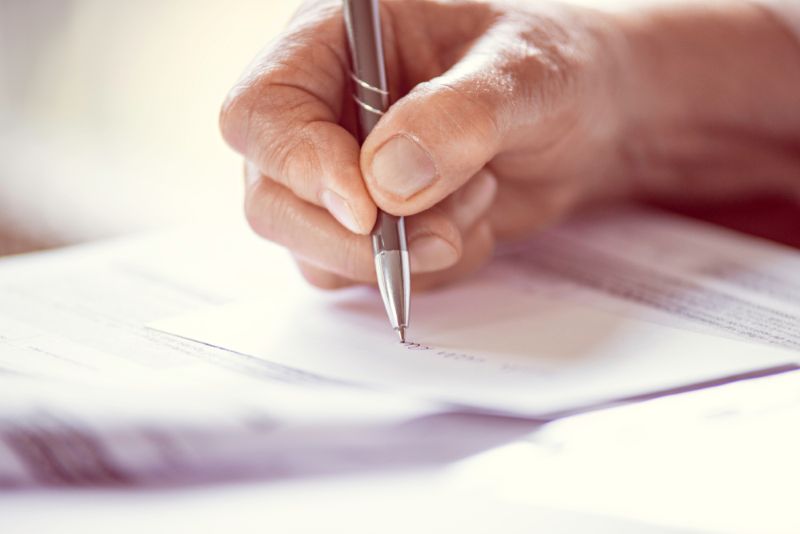 A closeup image of a pen writing on a piece of paper