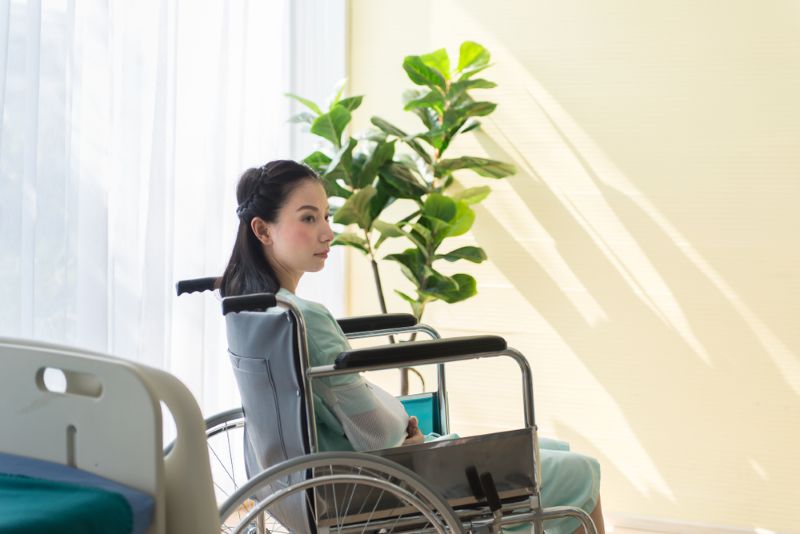 Injured woman in a hospital room sitting in a wheelchair