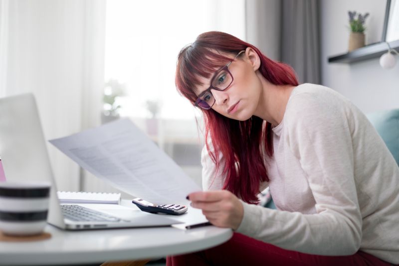 Woman reviewing finances at kitchen table