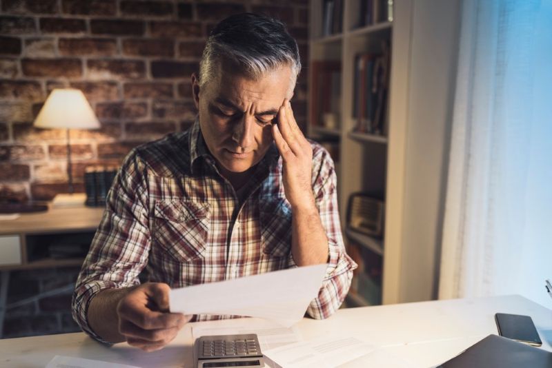 Stressed older man reading his mail